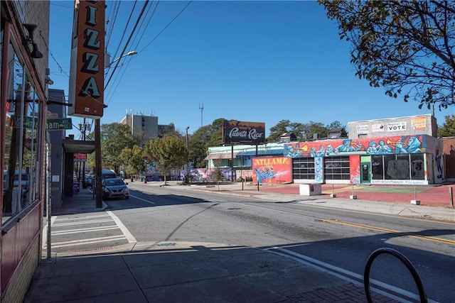 view of road featuring sidewalks, street lights, and curbs