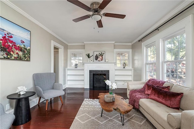 interior space featuring dark wood-style floors, a fireplace, crown molding, a ceiling fan, and baseboards