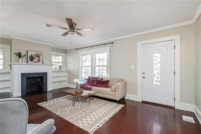 living room with crown molding, dark wood-style flooring, a fireplace, and baseboards