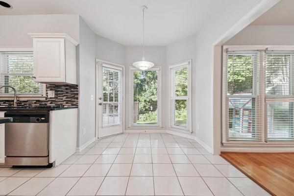 3272 Monarch Pine Dr, Peachtree Corners, GA 30071 - kitchen with stainless steel dishwasher, dark countertops, healthy amount of natural light, and tasteful backsplash