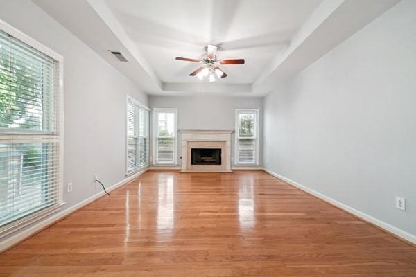 3272 Monarch Pine Dr, Peachtree Corners, GA 30071 - unfurnished living room with a ceiling fan, light wood-style flooring, a raised ceiling, and a fireplace with flush hearth