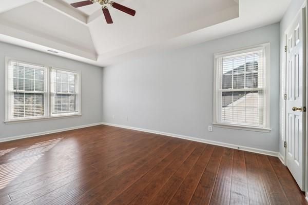 3272 Monarch Pine Dr, Peachtree Corners, GA 30071 - unfurnished room with a tray ceiling, dark wood-style floors, and a ceiling fan