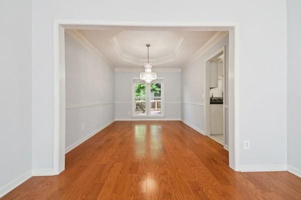 3272 Monarch Pine Dr, Peachtree Corners, GA 30071 - unfurnished dining area featuring wood finished floors, a chandelier, ornamental molding, and a tray ceiling