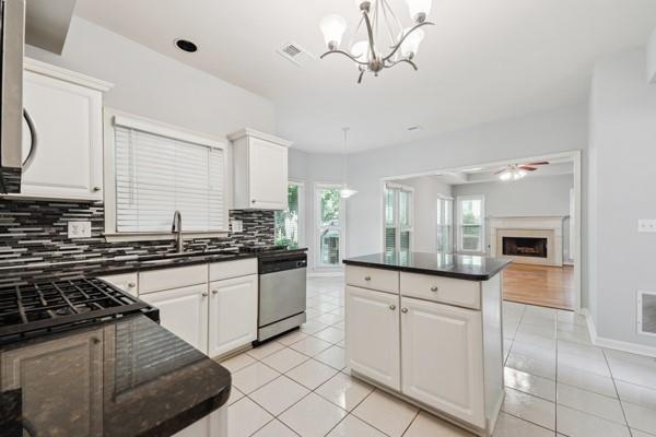3272 Monarch Pine Dr, Peachtree Corners, GA 30071 - kitchen with dishwasher, tasteful backsplash, a ceiling fan, a fireplace, and white cabinetry