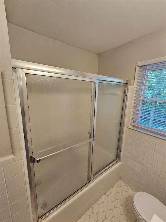 bathroom with tile walls and toilet