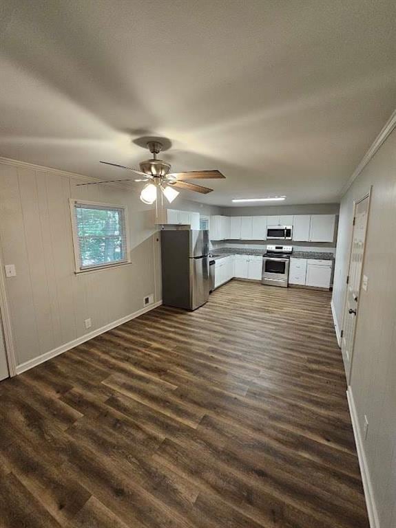 kitchen with white cabinetry, appliances with stainless steel finishes, baseboards, ceiling fan, and dark wood-style flooring