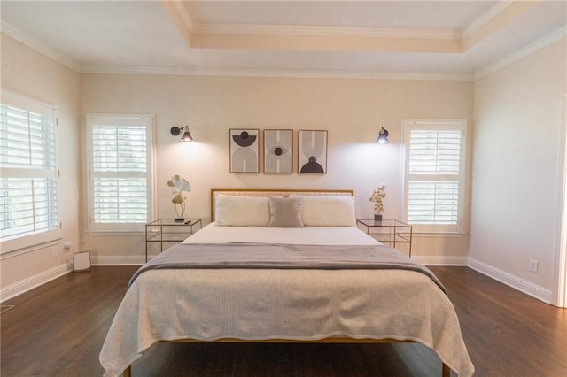 bedroom with dark hardwood / wood-style floors, a raised ceiling, and ornamental molding