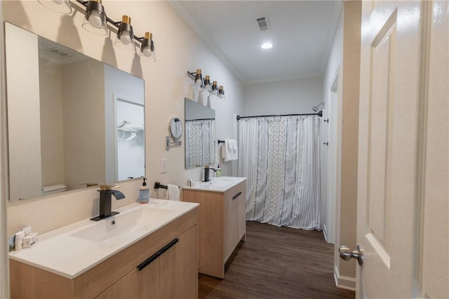 bathroom with hardwood / wood-style floors, vanity, and crown molding