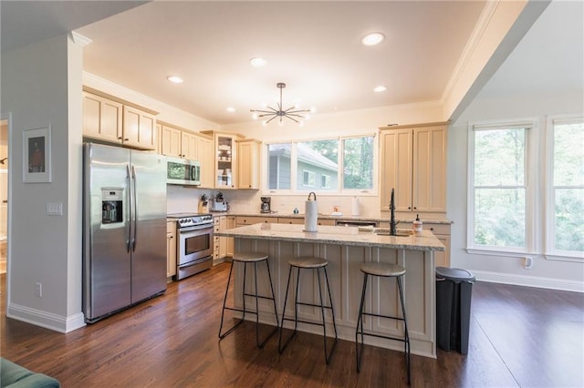 kitchen featuring a breakfast bar, dark wood-type flooring, a center island with sink, crown molding, and appliances with stainless steel finishes