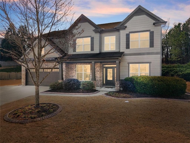 view of front of property with a garage, a front yard, concrete driveway, and brick siding