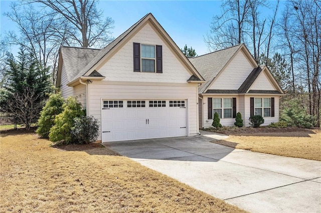 traditional home featuring concrete driveway and a shingled roof