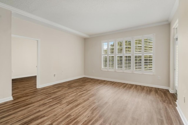 unfurnished room featuring wood-type flooring, a textured ceiling, and crown molding