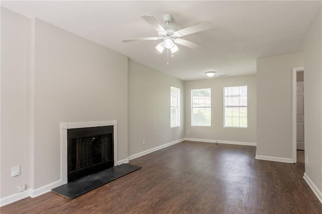 711 Ashley Ln, Stone Mountain, GA 30087 - unfurnished living room with dark wood finished floors, a fireplace with raised hearth, and a ceiling fan