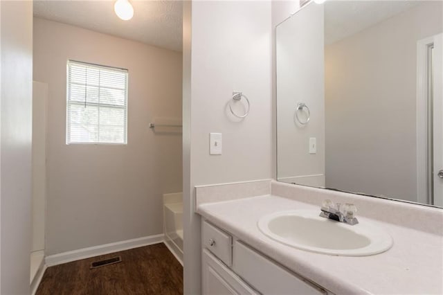 711 Ashley Ln, Stone Mountain, GA 30087 - bathroom featuring vanity, a bath, a textured ceiling, and wood finished floors