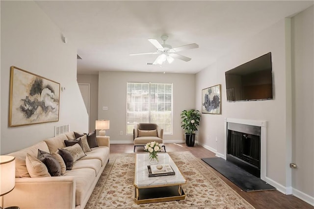 711 Ashley Ln, Stone Mountain, GA 30087 - living area featuring a ceiling fan, a fireplace with raised hearth, and wood finished floors