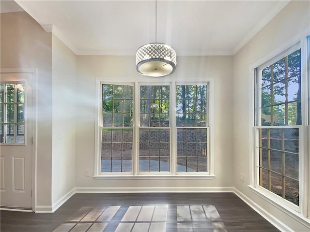 unfurnished dining area featuring dark hardwood / wood-style floors, a wealth of natural light, and crown molding