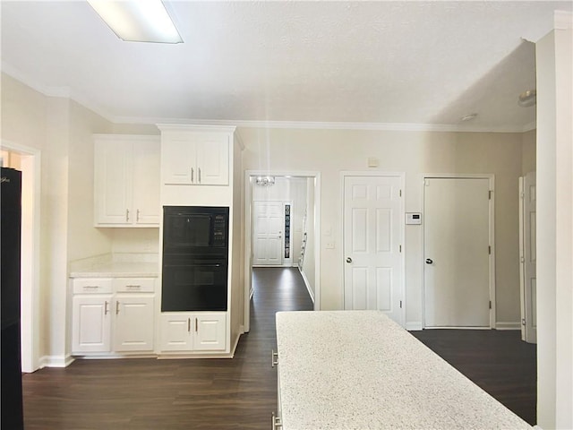 kitchen featuring dark hardwood / wood-style flooring, light stone counters, crown molding, black appliances, and white cabinetry