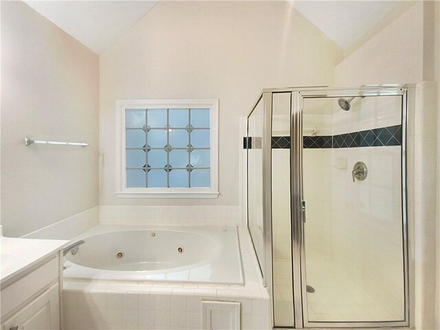 bathroom featuring shower with separate bathtub, vanity, and vaulted ceiling