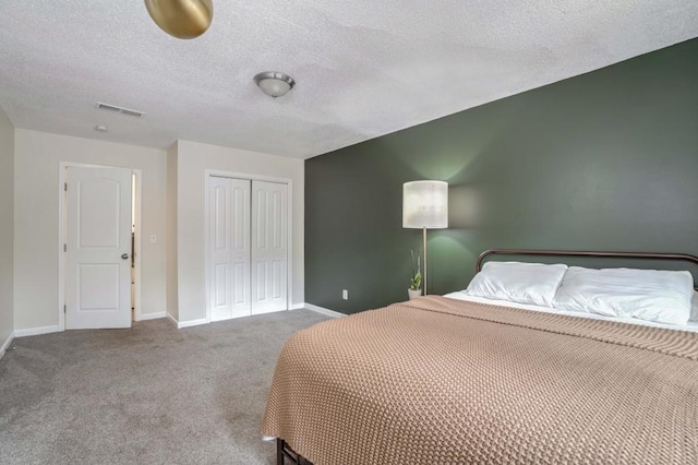 carpeted bedroom with a closet and a textured ceiling