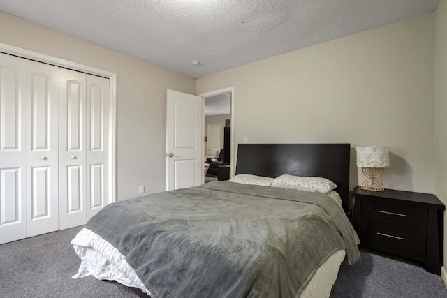 bedroom featuring a closet, a textured ceiling, and dark colored carpet