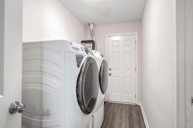 washroom with independent washer and dryer, a textured ceiling, and dark wood-type flooring