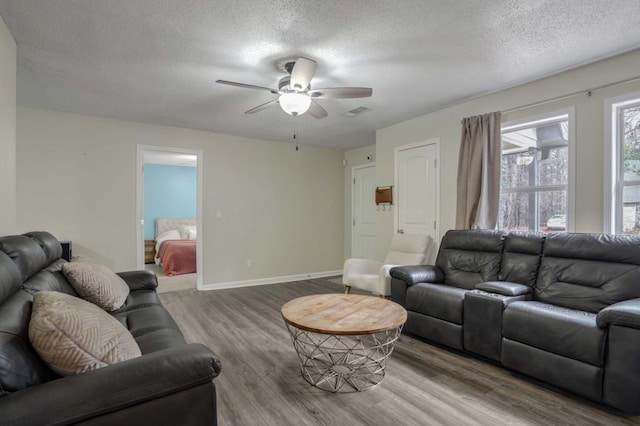 living room with ceiling fan, hardwood / wood-style floors, and a textured ceiling