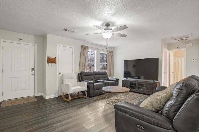 living room featuring ceiling fan, dark hardwood / wood-style flooring, and a textured ceiling