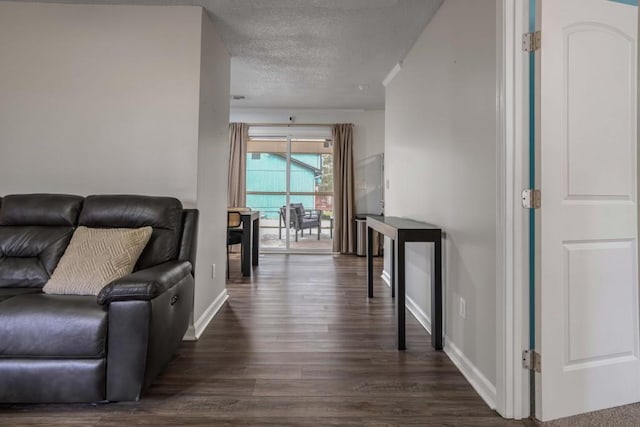 living room with dark hardwood / wood-style flooring and a textured ceiling