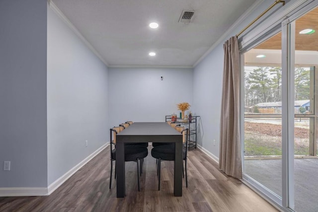 dining room with hardwood / wood-style flooring and ornamental molding