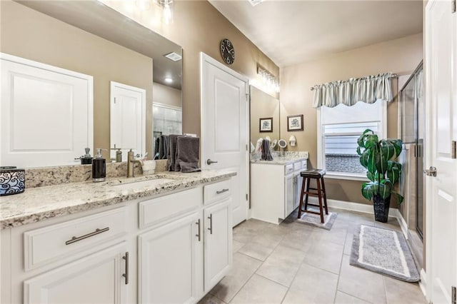 bathroom with tile patterned flooring, vanity, and a shower with door