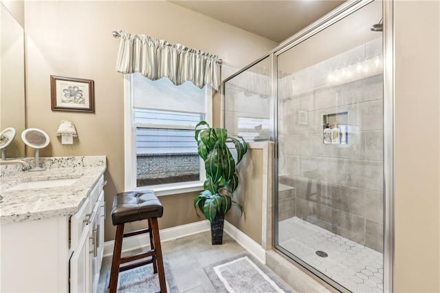 bathroom featuring a shower with door and vanity