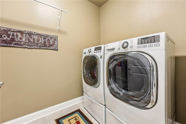 laundry room featuring light tile patterned flooring and washing machine and clothes dryer