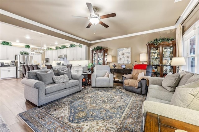 living room with ornamental molding, hardwood / wood-style flooring, and ceiling fan