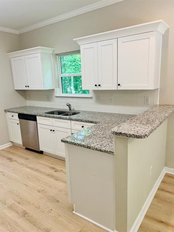 377 Fieldcrest Dr, Dallas, GA 30132 - kitchen with stainless steel dishwasher, a sink, a peninsula, light wood finished floors, and white cabinetry