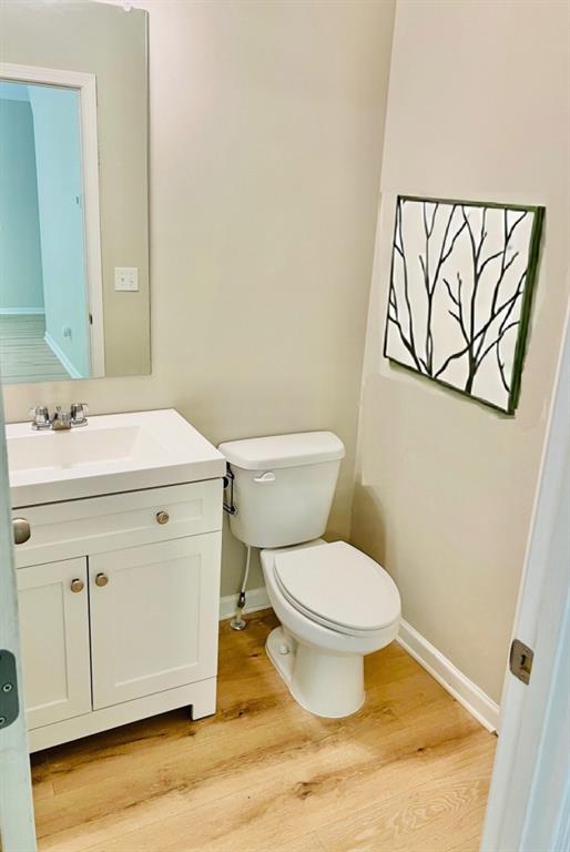 377 Fieldcrest Dr, Dallas, GA 30132 - half bath with vanity, toilet, wood finished floors, and baseboards