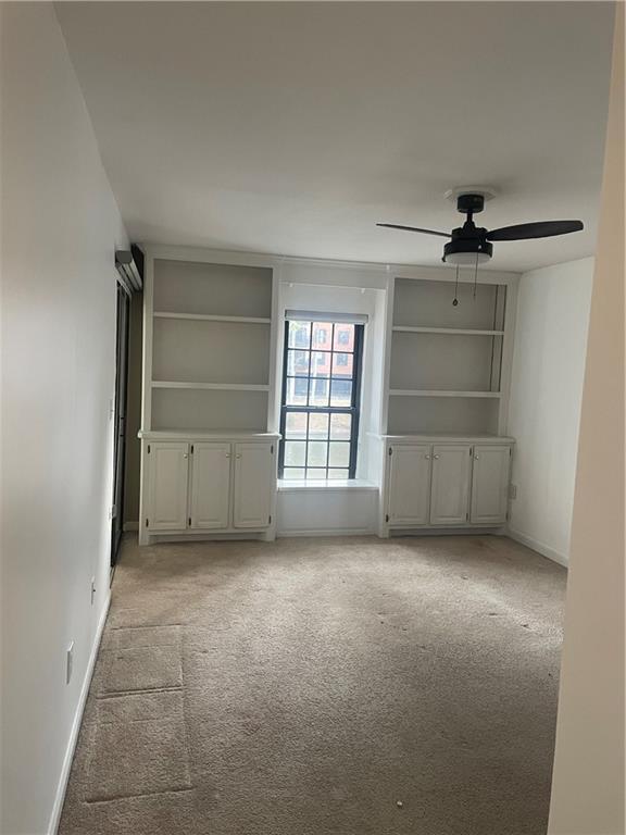 23210 Plantation Dr NE, Atlanta, GA 30324 - interior space featuring light carpet, ceiling fan, built in features, and baseboards