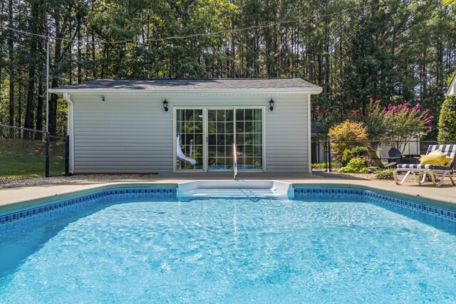 view of pool featuring an outdoor structure, fence, a patio, a fenced in pool, and an exterior structure
