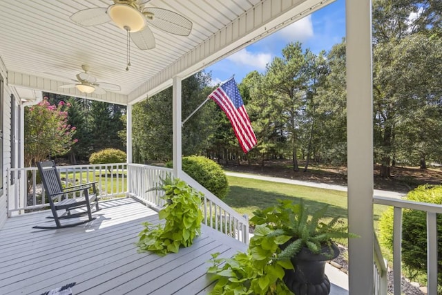 wooden deck featuring ceiling fan and a lawn