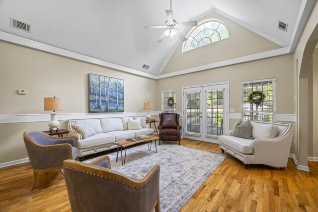 living room with a wealth of natural light, visible vents, and wood finished floors
