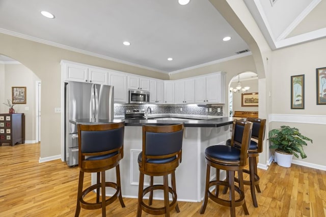 kitchen with white cabinetry, light hardwood / wood-style flooring, and stainless steel appliances