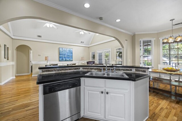 kitchen with a sink, stainless steel dishwasher, visible vents, white cabinets, and arched walkways