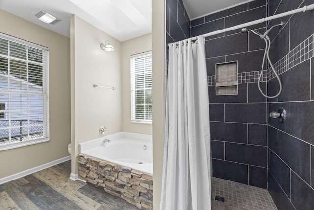 bathroom featuring toilet, wood-type flooring, plus walk in shower, and a skylight