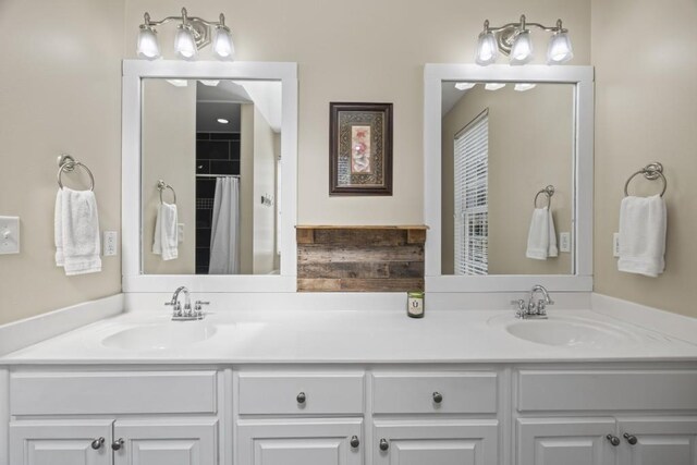 bathroom featuring a shower with curtain, double vanity, and a sink