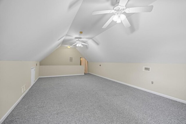 additional living space with carpet flooring, lofted ceiling, baseboards, visible vents, and ceiling fan