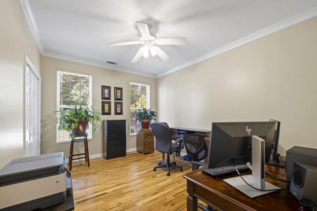 office area with crown molding, light wood-type flooring, baseboards, visible vents, and ceiling fan