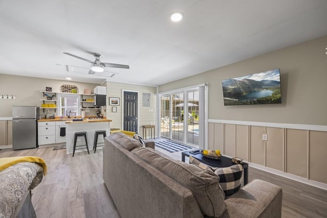 living room with ceiling fan and light hardwood / wood-style floors