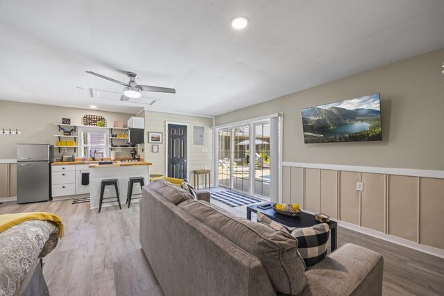 living room with a ceiling fan, recessed lighting, and light wood-type flooring