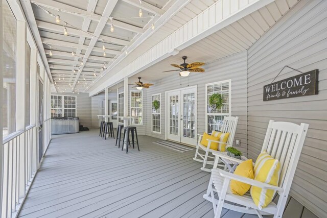 deck with outdoor dining space, french doors, and a ceiling fan