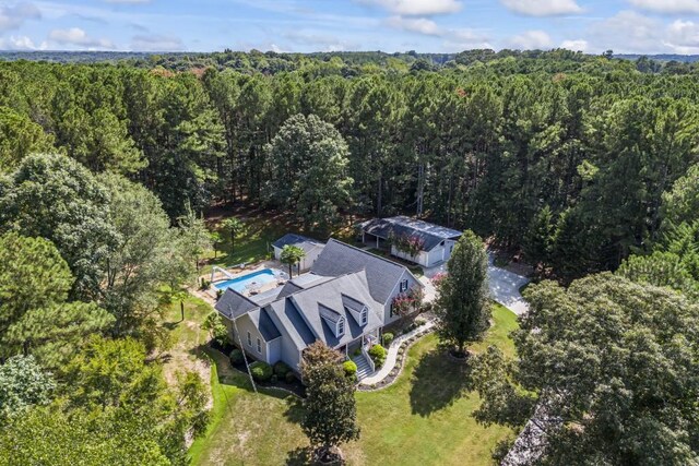 drone / aerial view featuring a wooded view