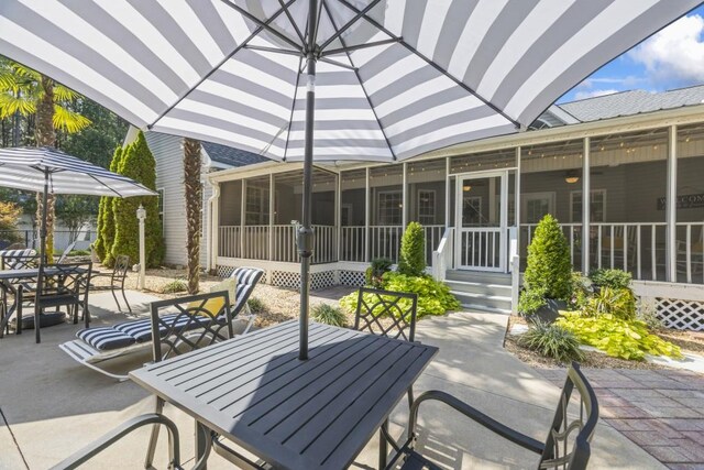 view of patio / terrace featuring a sunroom and outdoor dining area